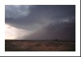 The cold air spilling out from the thunderstorm creates a massive wall of dust (often called a haboob) with very high winds, brief torrential rains and dust whirls but tornados are much less likely.