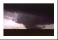 The tornado is actually past peak though the dust/debris column is quite large.  It has been on the ground for nearly fifteen minutes by this photo.