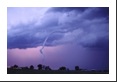 A flash from in-cloud lightning illuminates the cloud behind this tornado after sunset.