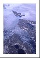 Glaciers giving birth to icebergs, sending them into the Atlantic Ocean as seen from 39,000 feet.