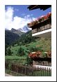 Porch-side flower boxes full of vibrant flowers are a trademark of Swiss living - the Matterhorn's peak is obscured by passing cloud.