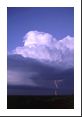 A very tilted supercell (storm tilts away from me) with mesocyclone spits out a cloud-to-ground lightning bolt. The updraft cumulus cloud also causes a pileus cloud to form at the top.